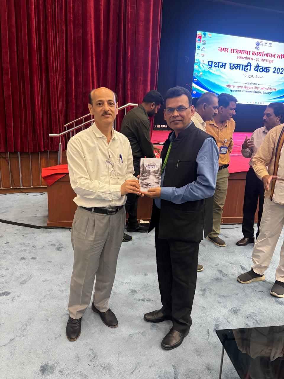 निदेशक महोदय, मौसम विज्ञान केंद्र, देहारादून द्वारा "अंतस" पुस्तक की प्रति उप निदेशक महोदय (ओएनजीसी देहारादून) को भेंट करते हुये जून 2026